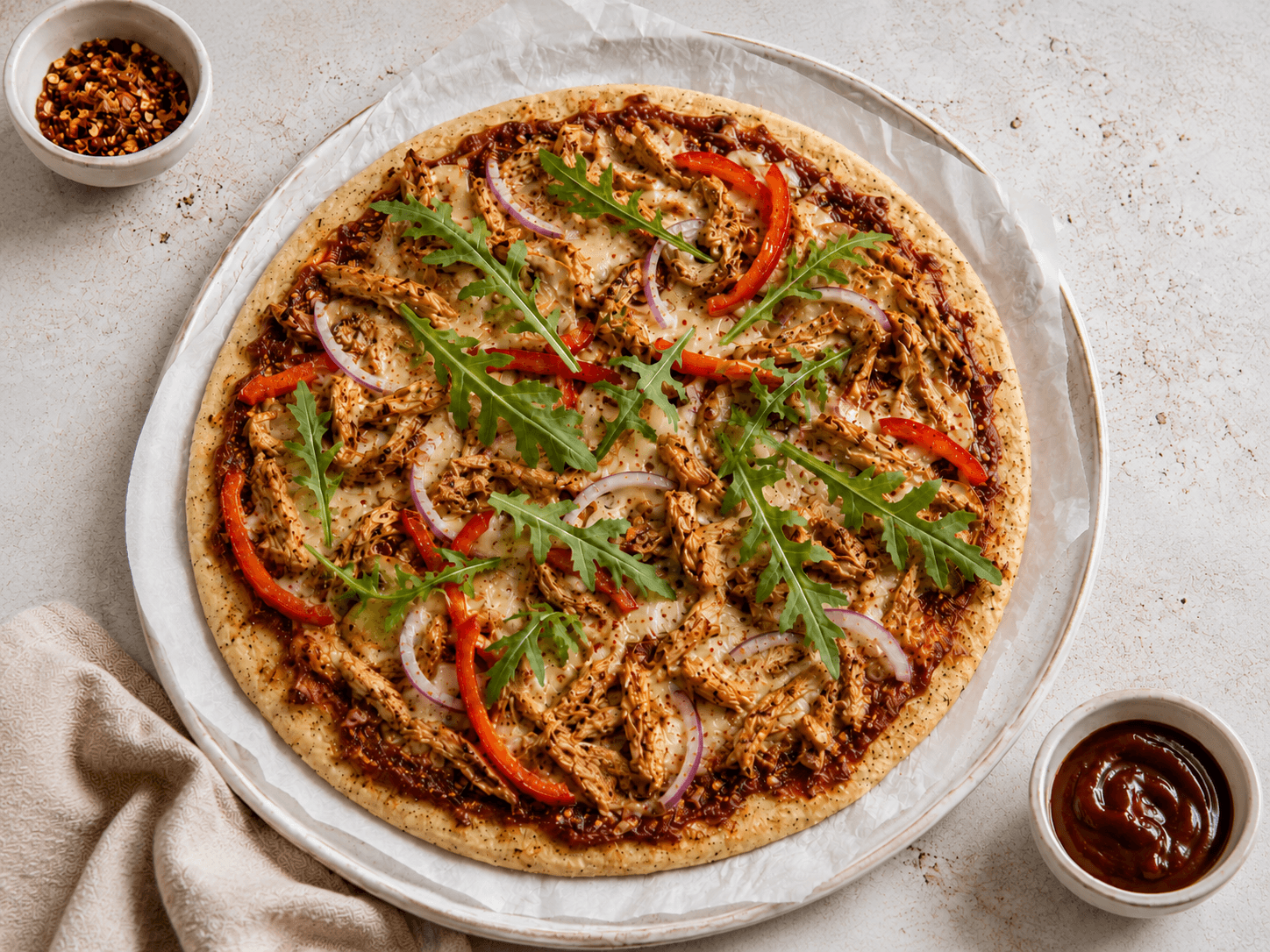 BBQ chicken flatbread pizza with shredded chicken, mozzarella, capsicum, red onion and rocket