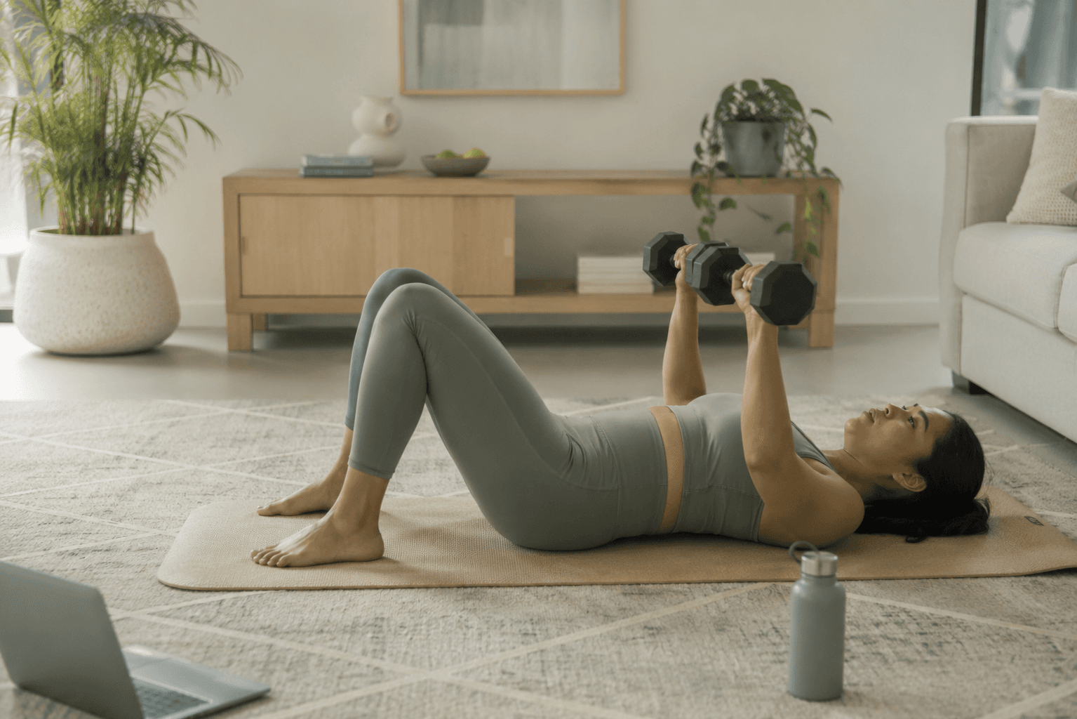 Person performing a floor press with dumbbells at home in a calm, relaxed setting